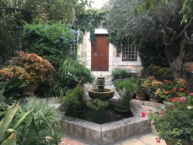 Patio d'un bâtiment ancien avec une fontaine: l'eau va vers le haut, ce qui est généralement recommmandé. Ce jardin intérieur offre un espace protégé, un havre de paix.